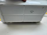 a person holding a white container on a table