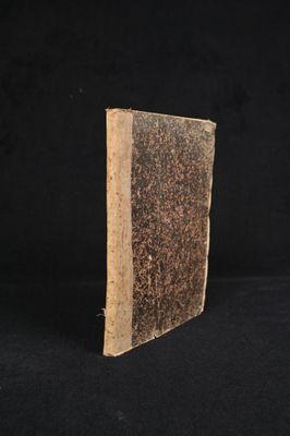 an old book sitting on top of a black surface