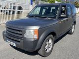 un Land Rover gris garé sur le bord de la route