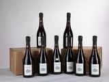 six bouteilles de vin sont alignées devant une boîte en carton