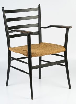 a black wooden chair with a woven seat and armrest