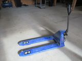 un chariot élévateur bleu posé au sol dans un garage