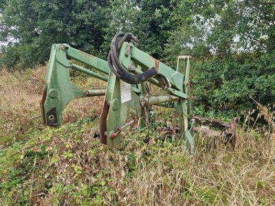 un tracteur vert qui est garé dans l'herbe