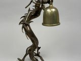 statue of a dragon holding a bell with a bell hanging from it ' s neck