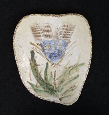 a picture of a decorative stone with a blue flower on it