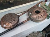 two antique copper cooking utensils sitting on a table