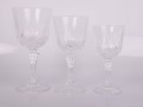 three clear wine glasses sitting on top of a white table