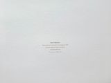an open book with a white cover sitting on top of a wooden table
