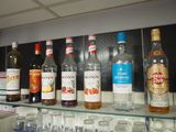 many bottles of alcohol sitting on a shelf next to glasses