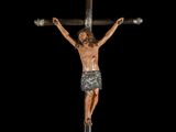 an image of a statue of jesus on a cross with a black background