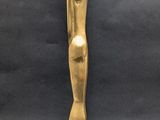 a gold statue of a woman standing on a wooden base