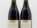 deux bouteilles de vin rouge posées l'une à côté de l'autre sur une surface blanche