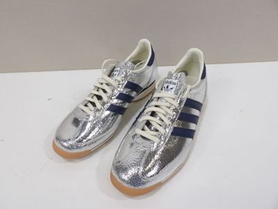 a pair of silver and blue sneakers on a white surface