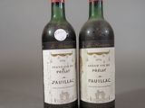 two bottles of red wine sitting next to each other on a table