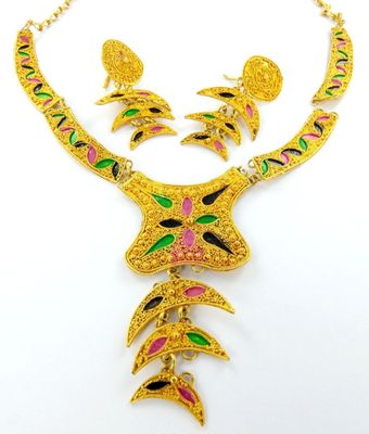 a close up of a necklace and earrings on a white surface