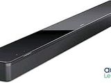 La barre de son est noire et est équipée d'une télécommande placée sur le dessus.