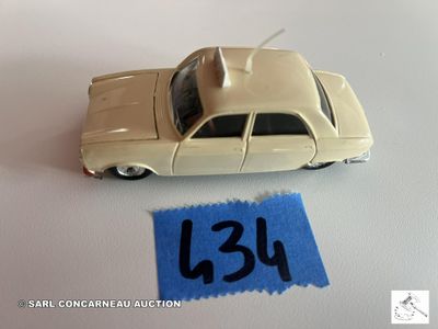 une petite voiture posée à côté d'une feuille de papier