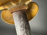 an old sword with a gold handle on a black background