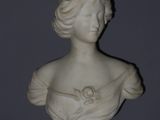 a white busturine of a woman with a flower in her hair