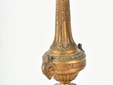 a gold candelab with a bird on top of it