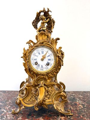 une horloge en or posée sur une table en marbre