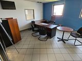 une pièce équipée d'un bureau, de chaises et d'une télévision
