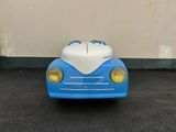 a blue toy car with a white top parked in a parking lot
