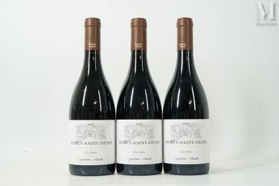 trois bouteilles de vin rouge sont posées sur une surface blanche