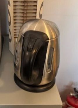 un grille-pain argenté et noir posé sur une boîte blanche