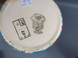 a white plate with a crest on it on a table