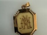 a picture of a pendant with a monogram on it
