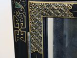 a black mirror with gold and green designs on it