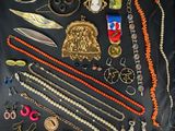 many different necklaces and bracelets laid out on a table