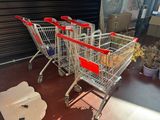 several shopping carts are lined up in a row in front of a garage door