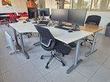 three computer screens on the desks in the room