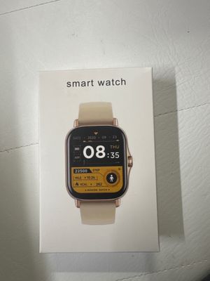 quelqu'un tient une montre connectée dans sa main, posée sur une table