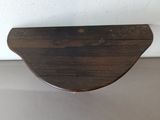 a wooden shelf that has a small piece of wood on top of it