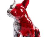 une figurine de chien rouge et noire posée sur une surface blanche