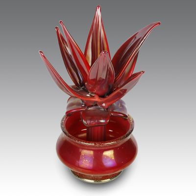 un vase en verre rouge contenant une fleur rouge