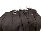 three suits are lined up on a hanger in a row