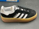 a pair of black and white adidas sneakers on a table