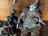 a small statue of a man holding a sword next to a small statue of a man holding a sword