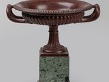 une image représentant un vase marron posé sur un socle en marbre vert
