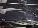 a reflection of a man in a mirror on a black car