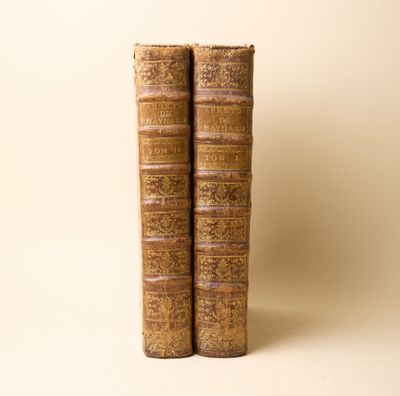 deux vieux livres posés l'un sur l'autre sur une table
