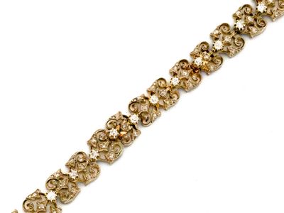 un gros plan d'un bracelet doré sur fond blanc