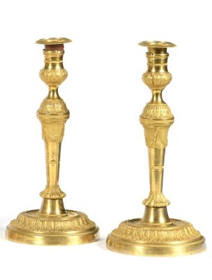 pair of antique brass candlesticks on a white background