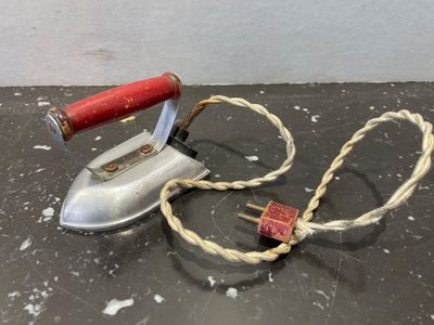 un vieux fer à repasser et une corde posés sur une table