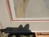 a shadow of a person standing in front of a picture