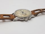 an image of a watch with a leather strap on a white surface